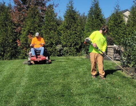 A man mowing a lawn with a lawn mower {{brizy_dc_image_alt imageSrc=